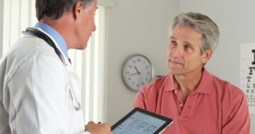 Senior doctor asking elderly patient questions